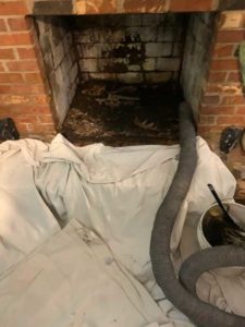 Chimney firebox cleaning with drop cloth and piping in front of chimney - West Tennessee Chimney