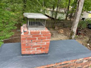 Chimney cap and flashing repair with mobil homes in the background - West Tennessee Chimney
