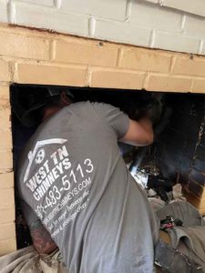Tech sweeping chimney with logo on shirt - West Tennessee Chimney