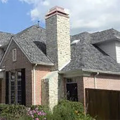 Stock photo of custom chimney cap - West Tennessee Chimney Custom chimney cap on tall white brick fireplace and landscaping around house