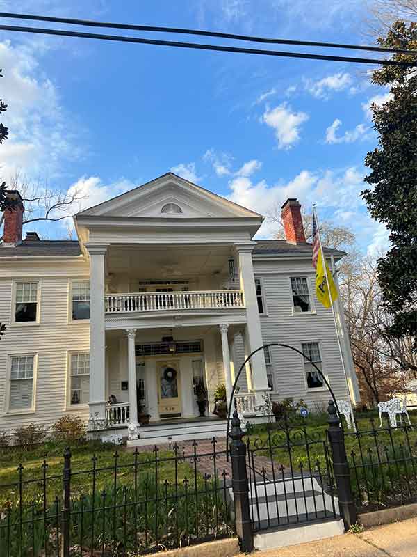 Beautiful old victorian home with two chimneys and iron fence 
