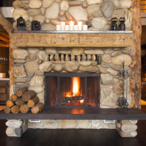 a stone fireplace with a stack of wood next to it