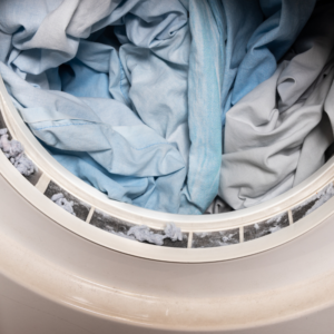 open dryer with blue clothes in it