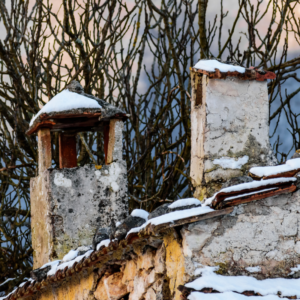 broken down stone chimneys with snow on top of them